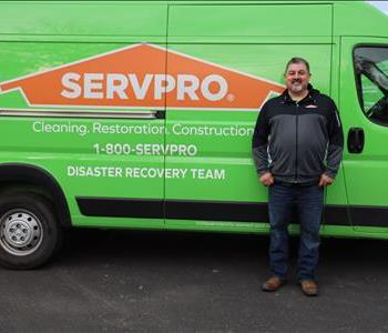 SERVPRO employee in front of green truck